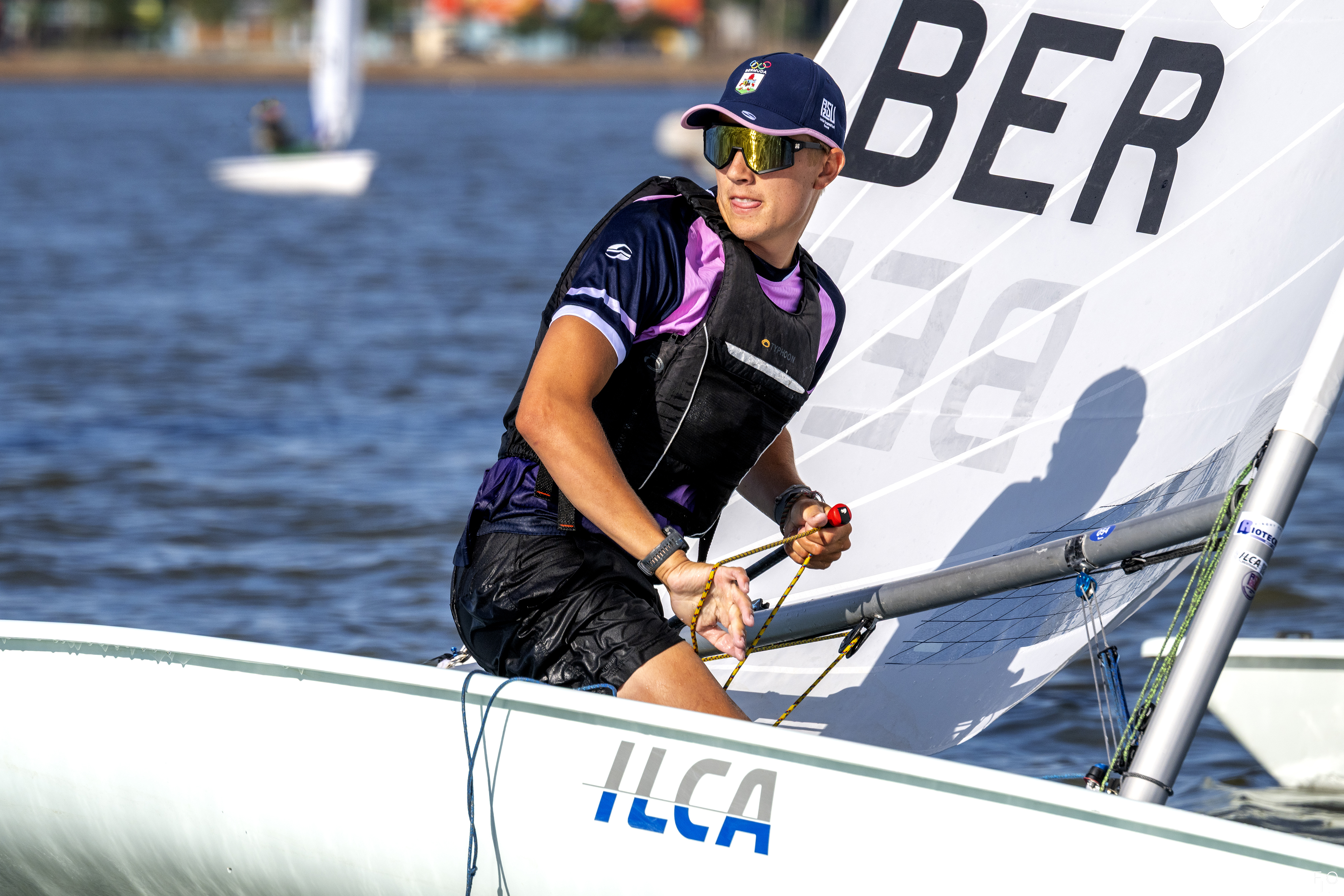 The image features a man participating in sailing activities. He is wearing a black life jacket that has clipped edges of ...